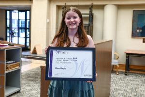 Research Prize Winner Allison Magee holding framed certificate.
