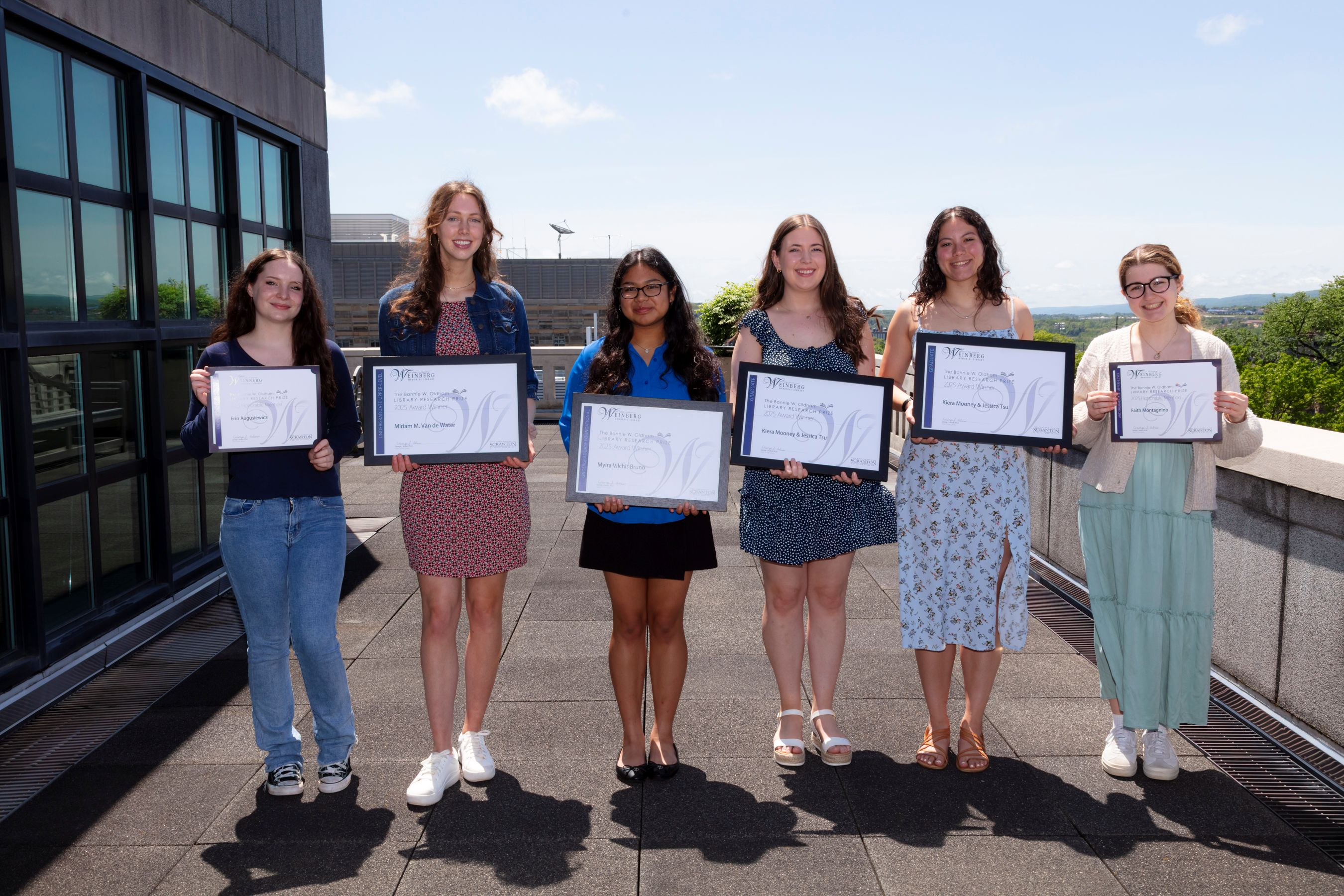 Research Prize honorees holding frames certificates.