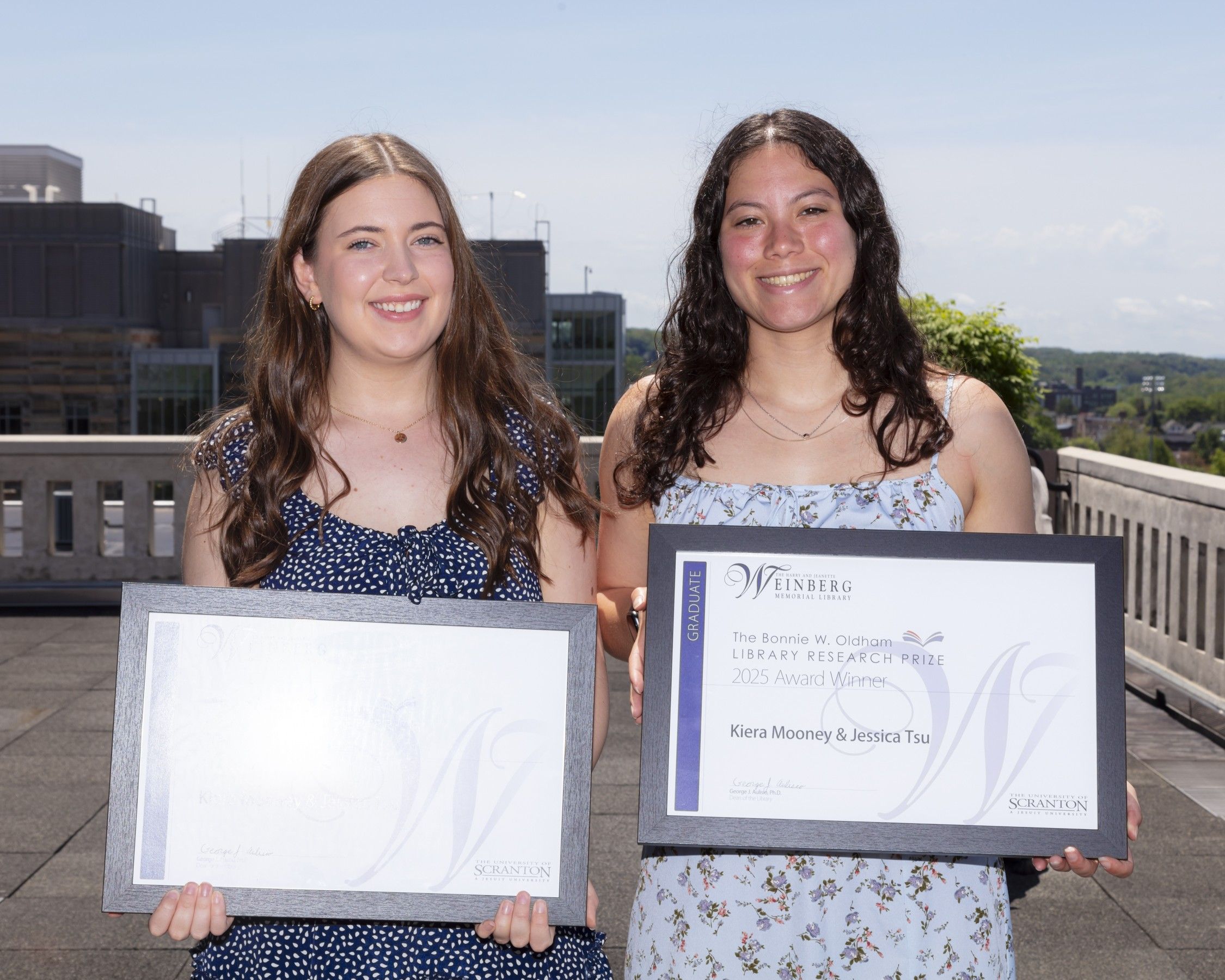Research Prize Winners Kiera Mooney and Jessica Tsu holding framed certificates.