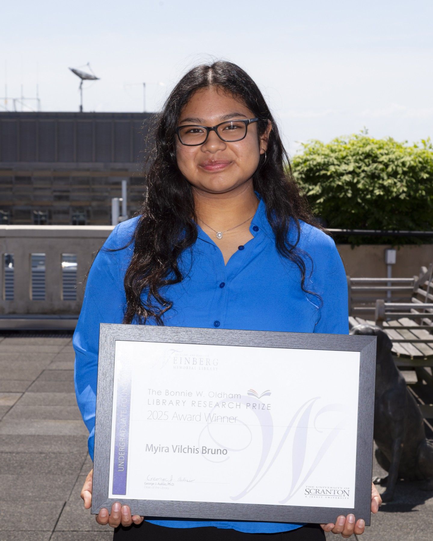 Research Prize Winner Myira Vilchis Bruno holding framed certificate.